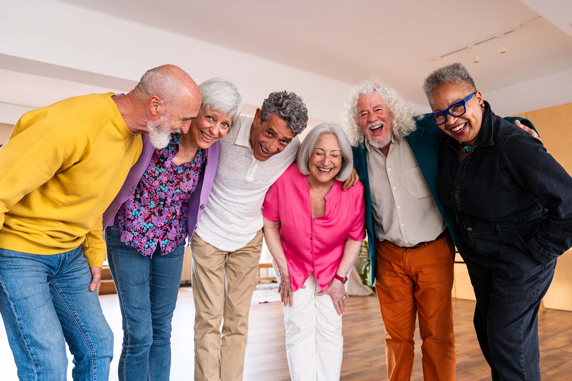 Group of happy senior friends bonding at home for dinner party - Cheerful and youthful old mature multiethnic people having fun